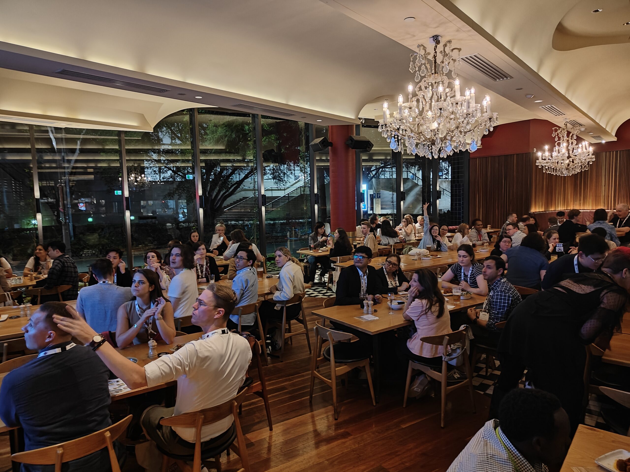 Men and women sitting around tables at the Brisbane ECR evening event participating in the pub quiz.