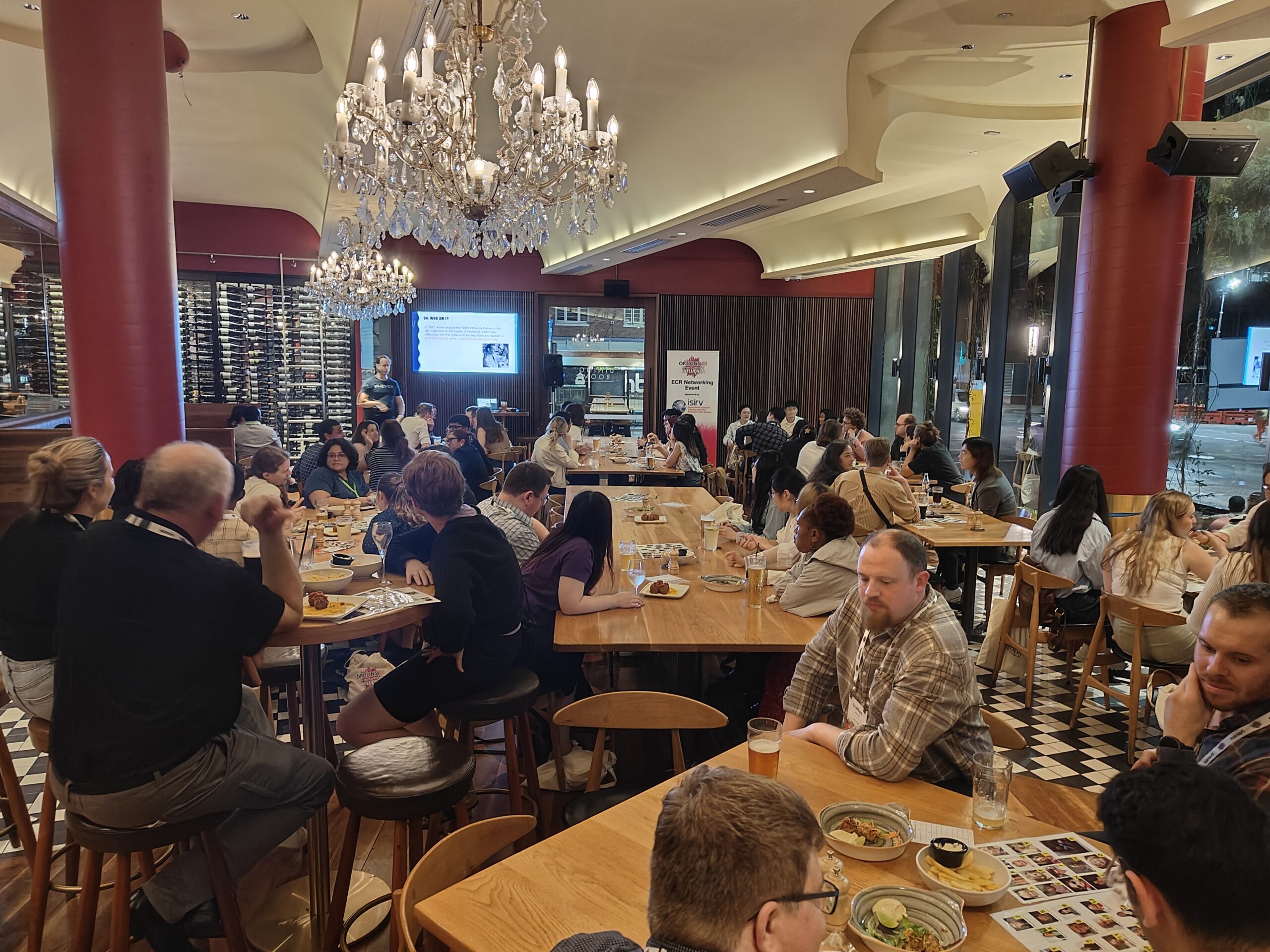 Men and women sitting at tables participating in the ECR evening pub quiz in Brisbane, 2024.
